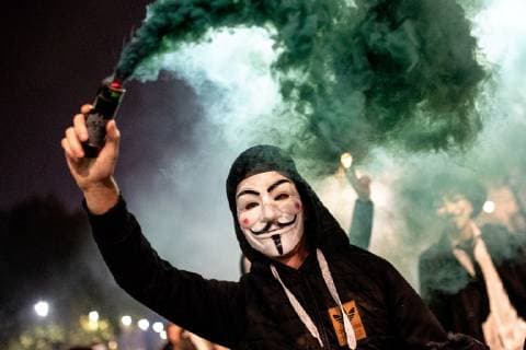 November 5, 2018 - London, London, UK - London, UK. A demonstrator lights a flare as he takes part in the Million Mask March, an anti-capitalist protest organised by Anonymous UK. The march takes place on bonfire night, the anniversary of Guy Fawkes plot to blow up the Houses of Parliament with gunpowder. London UK - ZUMAl94_ 20181105_zaf_l94_067 Copyright: xTomxNicholsonx