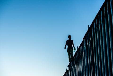Nov 14, 2018 - Tijuana, Mexico - Asylum seeker from Central America, aka the Migrant Caravan , walks atop the border fence at the US Mexico border in Tijuana. Tijuana Mexico - ZUMAs157 20181114_tim_s157_019 Copyright: xVitoxDixStefanox