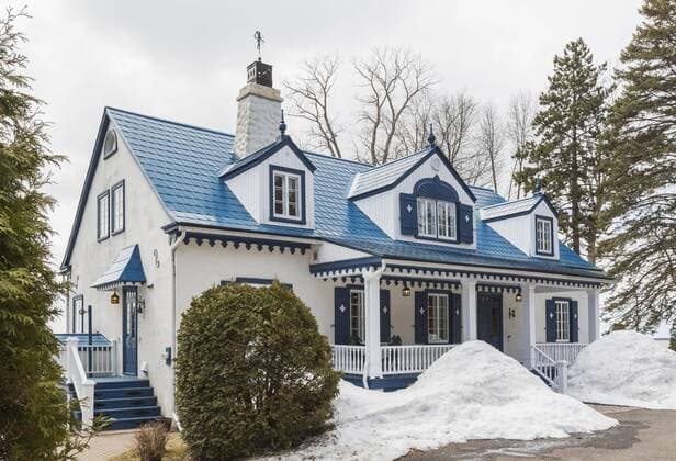 Alter 20er Jahre weißer Rohputz mit blauer Hausfassade im Landhausstil mit blauem Stahlziegeldach im Frühjahr, Quebec, Kanada, Nordamerika Copyright: imageBROKER/PerryxMastrovito ibxpmt04780010.jpg
