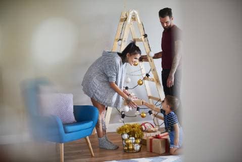 Modern family at home at Christmas time using ladder as Christmas tree model released Symbolfoto property released  ABIF01066