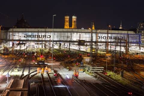 Beleuchteter Hauptbahnhof mit Gleisen bei Nacht, hinten Frauenkirche, München, Deutschland, Europa Copyright: imageBROKER/MarcxRasmus iblmra04743201.jpg
