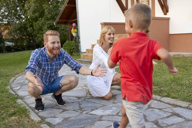 Boy running towards happy parents on garden path model released Symbolfoto property released  ZEDF01574
