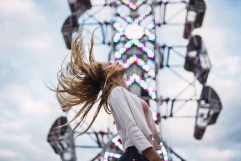 Long-haired young woman shaking her hair on a funfair model released Symbolfoto  KKAF02015