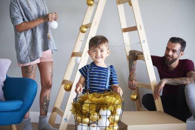 Modern family decorating the home at Christmas time using ladder as Christmas tree model released Symbolfoto property released  ABIF01057