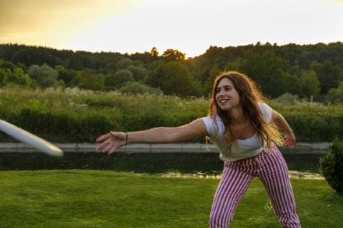 Young woman throwing flying disc model released Symbolfoto  LBF02090