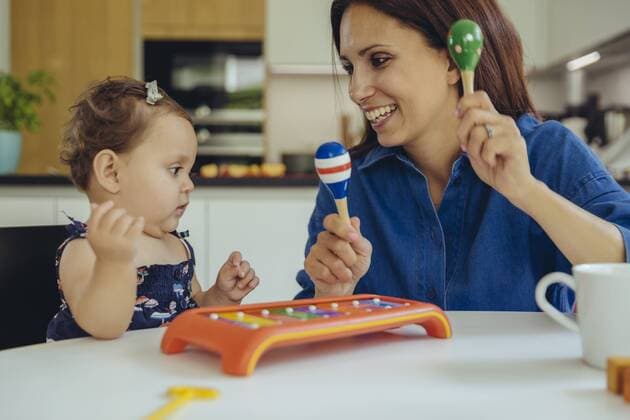 Happy mother and baby daughter playing with rattles model released Symbolfoto property released  MFF04659