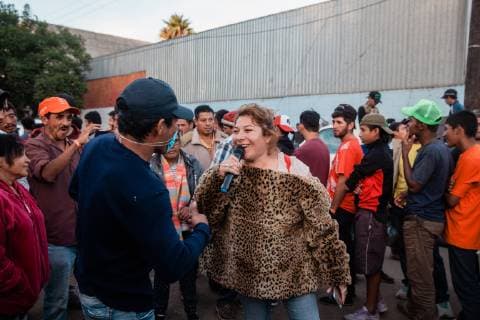 A woman sings to try to keep spirits up in front of the makeshift migrant shelter at Unidad Deportiva Benito Juarez Stadium on November 26, 2018 in Tijuana, Mexico. Sunday afternoon, some migrants protesting a backlog of asylum claims rushed toward the border and were met with tear gas.  TIJ2018112613 ARIANAxDREHSLER