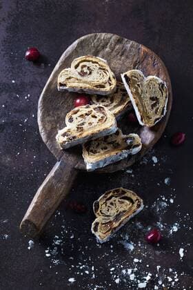Sliced Christmas Stollen with icing sugar on a wooden scoop  CSF28496