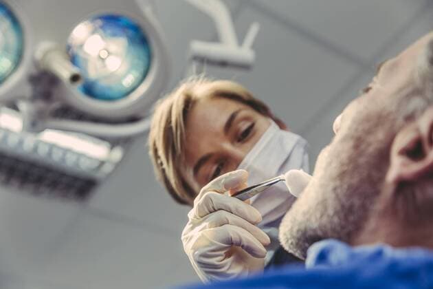 Dental surgeon during surgical procedure on a patient model released Symbolfoto property released  MFF04571