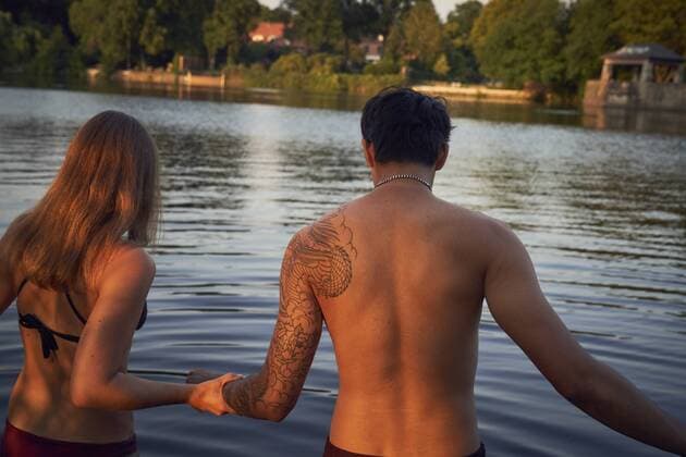 Young couple going into a lake, bathing model released Symbolfoto  SRYF00854