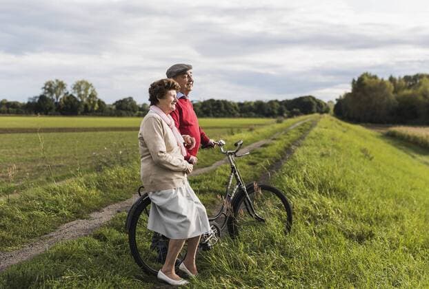 Senior couple with bicycles in rural landscape model released Symbolfoto  UUF12033