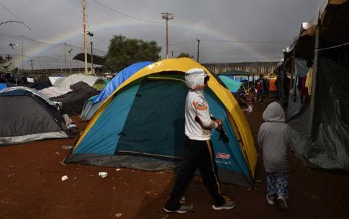November 29, 2018 - Tijuana, Mexico - A rainbow briefly appears over camp. People navigate severe flooding at the migrant caravan camp Centro Deportivo Benito Juarez on November 29, 2018. It is being called a humanitarian crisis. We lost everything, said a migrant walking through debris. Many migrants appeared to realize that the hope they held to begin a new life in America had dimmed and their stay in Mexico may be longer than anticipated. Tijuana Mexico - ZUMAg208 20181129_zap_g208_009 Copyright: xCarolxGuzyx