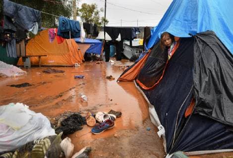 November 29, 2018 - Tijuana, Mexico - People navigate severe flooding at the migrant caravan camp Centro Deportivo Benito Juarez on November 29, 2018. It is being called a humanitarian crisis. IMELDA LIMA LOPEZ and her twins look at dirty water at their tent. SAIRA MAVEC MEZA, 5 years old, developed a rash from the tear gas said her mother. They were the focus of an image by Reuters photojournalist Kim Kyung-Hoon taken as they ran from tear gas fired by U.S. agents during chaos at the border on Sunday. The photo went viral. She came from Honduras with five children. She has nine total, 3 still in Honduras and 1 in Louisiana. We lost everything, said a migrant walking through debris. Many migrants appeared to realize that the hope they held to begin a new life in America had dimmed and their stay in Mexico may be longer than anticip - ZUMAg208 20181129_zap_g208_018 Copyright: xCarolxGuzyx