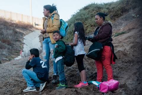 A family looks back at the border fence that divides the United States and Mexico near Las Playas de Tijuana, after jumping the fence and entering the U.S. in San Ysidro, California on December 2, 2018.  SAN2018120212 ARIANAxDREHSLER