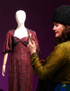 MOSCOW, RUSSIA - DECEMBER 4, 2018: A woman seen by a shot silk evening gown by the Frank Usher fashion house (London, early 1980s), on display at an exhibition titled The Glamour of the 80s by Russian fashion historian Alexandre Vassiliev opened at the VDNKh exhibition centre. The exhibition shows a unique collection of the 1980s costumes by Chanel, Christian Dior, Yves Saint Laurent, Givenchy, Pierre Balmain, Claude Montana, and other fashion houses. Mikhail Tereshchenko TASS TS099CBA