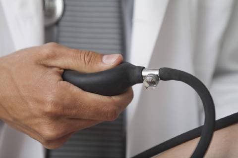 Doctor squeezing bulb on blood pressure gauge, cropped  Copyright: AlexVentura B08049120