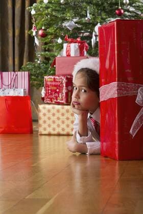 Boy waiting impatiently behind large Christmas present  Copyright: FrédéricxCirou B12527327