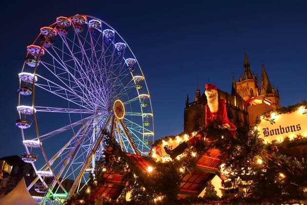 Erfurter Weihnachtsmarkt - GER, Germany, Deutschland, Berlin, 18.12.2018 - Erfurt (Thüringen): Bereits zum 168. Mal findet der Weihnachtsmarkt im Zentrum der Landeshauptstadt auf dem Domplatz statt. Zahlreiche Anbieter und Händler bieten anspruchsvolles Kunsthandwerk und manigfache Leckerbissen zum Kauf. Im Hintergrund des Weihnachtsmarktes befindet sich das einzigartige monumentale Ensemble aus Mariendom und Severikirche. - Aufgrund des Terroranschlags vom 19.12.2016 auf den Weihnachtsmarkt am Breitscheidplatz in der Berliner City wurden aktuell zum Schutz der Bevölkerung auch im Bereich des Erfurter Weihnachtsmarktes umfangreiche Sicherheitsvorkehrungen getroffen. - Weihnachtsmann vor beleuchtetem Riesenrad. Erfurt - Weihnachtsmarkt 2018