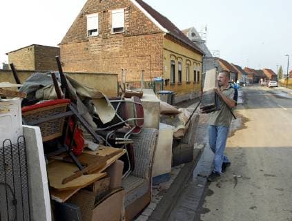 A man carrys furniture from his flooded house in the village Seegrehna, near Wittenberg, eastern Germany, Tuesday, Aug. 27, 2002. The swollen Elbe river floods this village in Saxony-Anhalt last week.( Eckehard Schulz) SEEGREHNA DEU