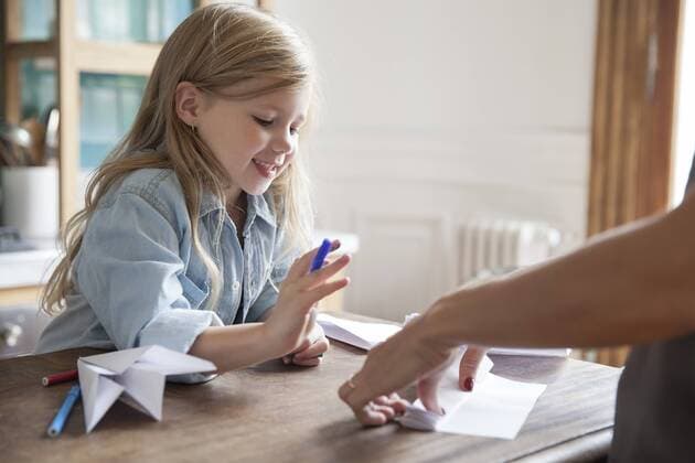 Little girl learning how to make paper airplane  Copyright: SigridxOlsson B10499822
