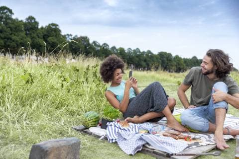 Happy couple having a barbecue and taking cell phone pictures in the nature model released Symbolfoto  FMKF05288