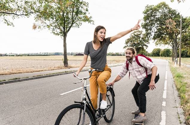 Happy young couple with bicycle and skateboard on country road model released Symbolfoto  UUF15444