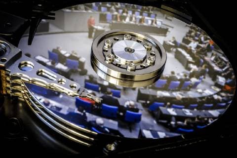 Symbolfoto zum Thema: Hackerangriff auf den Bundestag Ein Foto vom Plenum des Deutschen Bundestages spiegelt sich auf der Festplatte eines Computers. Berlin, 07.01.2019. Berlin Deutschland