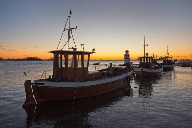 Europa; Deutschland; Mecklenburg-Vorpommern; Rügen; Ostsee: Fischerboote vor kleinem Leuchtturm bei Waase auf derOstseeinsel Ummanz