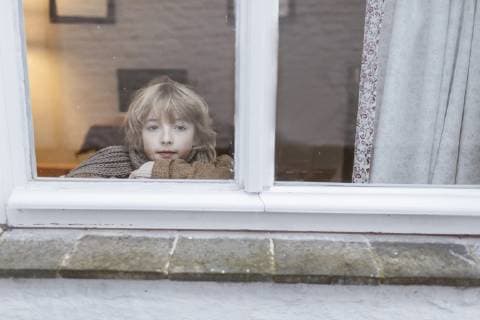 IMAGO Creative: Countdown bis Weihnachten, Wunschzettel schreiben Portrait of pensive boy looking out of window model released Symbolfoto  KMKF00122