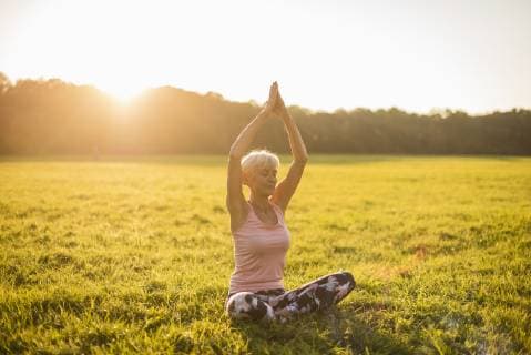 Senior woman doing yoga on rural meadow at sunset model released Symbolfoto  DIGF05471