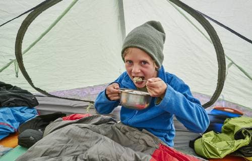 Bolivia, La Paz, boy eating from bowl in tent model released Symbolfoto  SSCF00040