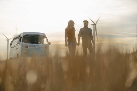 IMAGO Creative: Sommer, Abendspaziergang Young couple hand in hand at camper van in rural landscape at sunset model released Symbolfoto  GUSF01648