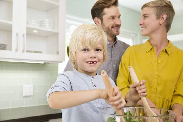 Smiling family preparing salad in kitchen together model released Symbolfoto property released  MFRF01072