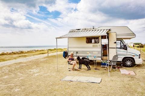  Frau sitzt im Urlaub mit einem Hund, Königspudel vor ihrem Wohnmobil am Meer, Portbail, Normandie, Frankreich, Europa *** Woman sitting on holiday with a dog king poodle in front of her camper by the sea Portbail Normandy France Europe Copyright: imageBROKER/JanxTepass ibxjte04830949.jpg