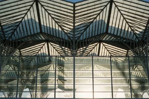 Architektur von Santiago Calatrava Der Bahnhof Estacao do Oriente, auch Gare do Oriente, zu Deutsch Ostbahnhof, ist ein Fern- und Regionalbahnhof im äußersten Nordosten Lissabons am Gelände der früheren Expo 1998, heute Parque das Nacoes. Er liegt an der Linha do Norte und wird jährlich von 75 Millionen Reisenden frequentiert. Der Bahnhof wurde als Eingang der Expo98 errichtet, entsprechend großzügig ist er gestaltet. Interessant sind insbesondere die Stahlbetontragwerke der Gleise, die trotz ihrer Massivität durch abgerundete Formen einen futuristischen Eindruck vermitteln. Die Bogenform prägt die Eingangsebene und setzt sich in vielen Details wie zum Beispiel dem abgerundeten flügelförmigen Vordach fort. *** The railway station Estacao do Oriente also Gare do Oriente to German Ostbahnhof is a long-distance and regional railway station in the extreme northe