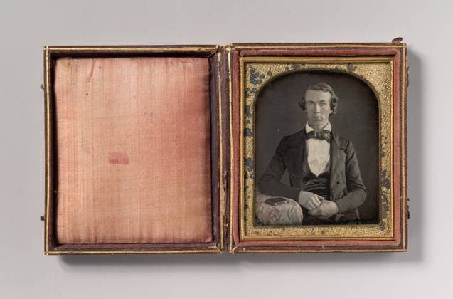 Seated Young Man Resting Arm on Table Beside Daguerreotype Case , 1840s, Daguerreotype, Image: 6.9 x 5.5 cm (2 11 16 x 2 3 16 in.), Photographs, Unknown (American), The daguerreotype, the first photographic process, was invented by Louis-Jacques-Mande Daguerre (French, 1787 1851) and spread rapidly around the world after its presentation to the public in Paris in 1839  Copyright: Artokoloro AM170720_062854