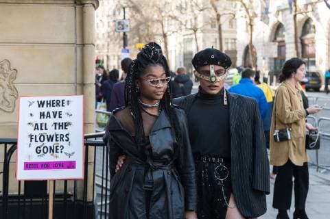News Bilder des Tages February 17, 2019 - London, Greater London, United Kingdom - Guests arrving at London Fashion Week on 17 February, 2019 walk past a protest sign. Protesters from Extinction Rebellion call for the British Fashion Council to influence fashion industry to stop the trend of excessive consumption and unsustainable growth in the face of climate change and ecological collapse. Textiles production contributes 1.2 billion tonnes of carbon emissions annually and textiles are the largest single source (34.8%) of microplastic pollution affecting marine life. London United Kingdom  - ZUMAn230 20190217_zaa_n230_196 Copyright: xWiktorxSzymanowiczx
