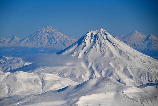 KAMCHATKA TERRITORY, RUSSIA - FEBRUARY 22, 2019: An aerial view of Mount Vilyuchinsky (Vilyuchik) in South Kamchatka Nature Park on the Kamchatka Peninsula in Russia s Far East; South Kamchatka Nature Park was created in 1995 and included in the UNESCO World Cultural and Natural Heritage List under the name of Volcanoes of Kamchatka, in 1996; the landscape of South Kamchatka Nature Park features active volcanoes (stratovolcanoes) and glaciers. Yuri Smityuk TASS  TS0A1EDB