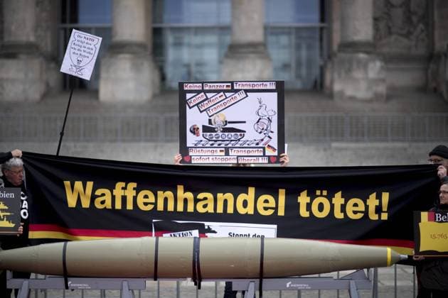 Aktion gegen Waffenhandel DEU, Deutschland, Germany, Berlin, 26.02.2019 Demonstranten mit Plakat Stoppt den Waffenhandel der Kampagne der Aktion - Stoppt den Waffenhandel, Aufschrei Gegen den Export von Terror und Gewalt made in Germany - unter dem Motto Ruestungsexporte stoppen Den Frieden Stark Machen fordern im Rahmen einer politischen Kampagne ein Verbot des deutschen Waffenhandels vor dem Reichstag, Deutscher Bundestag in Berlin. Deutschland ist drittgroesster Waffenexporteur der Welt. Aktion der Friedensbewegung gegen Exporte von Waffen und Ruestungsexporte nach Saudi-Arabien. Protest of the peace movement against the export of wappons under the slogan Action Outcry - Stop the arms trade in front of the Reichstag, the German Parliament, in Berlin, Germany. Demonstrators protest against arms exports in front of the German Bundestag o