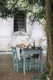 Laid garden table with candles next to a cottage  ALBF00718