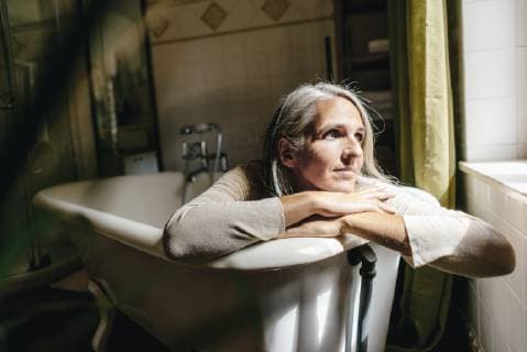Portrait of sad woman sitting dressed in bathtub model released Symbolfoto property released  KNSF03459