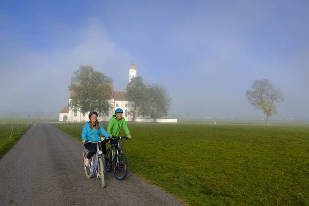 Germany, Pilgrimage Church St. Coloman and couple of cyclists on tour model released Symbolfoto  LBF02332