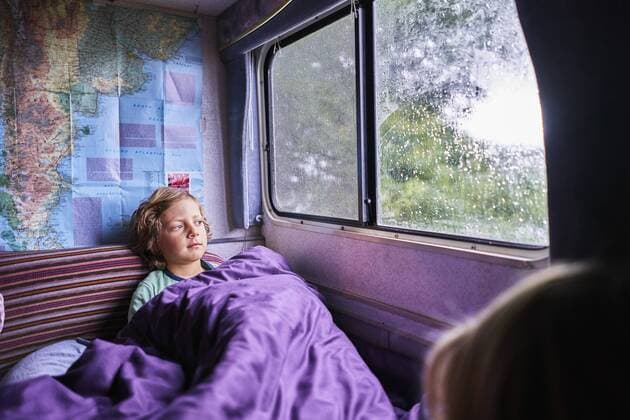 Boy in pyjama looking out of window of a camper model released Symbolfoto property released  SSCF00163