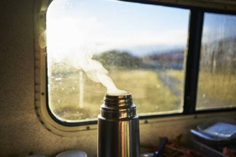 IMAGO Creative: Klimawandel - Nachhaltiges Reisen Steaming thermos flask in camper property released  SSCF00260
