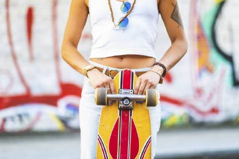 Close-up of young woman with skateboard at graffiti wall model released Symbolfoto  WPEF00783