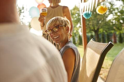 Smiling mature woman looking at husband on a garden party model released Symbolfoto property released  ZEDF01624
