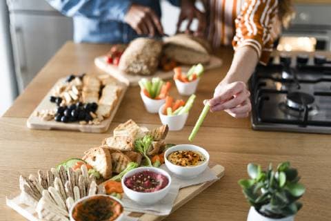 Couple preparing dinner party, hand garnishing dips model released Symbolfoto property released  ERRF00532