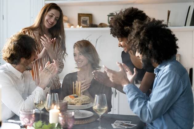 Geburtstag - Symbolbilder Friends celbrating birthday of a young woman, blowing out birthday candles model released Symbolfoto property released  ERRF00601