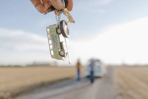 Hand holding camper van key in rural landscape model released Symbolfoto  GUSF01390