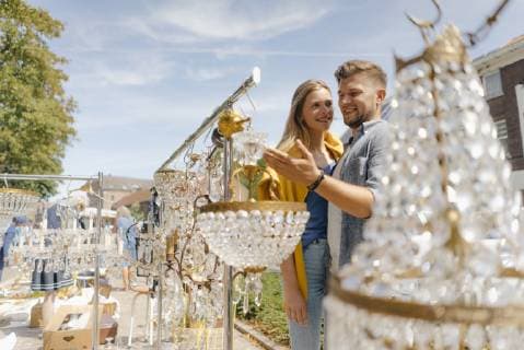 IMAGO Creative, Jahreszeit Sommer, Sommer in der Stadt Belgium, Tongeren, smiling young couple on an antique flea market model released Symbolfoto  GUSF01489